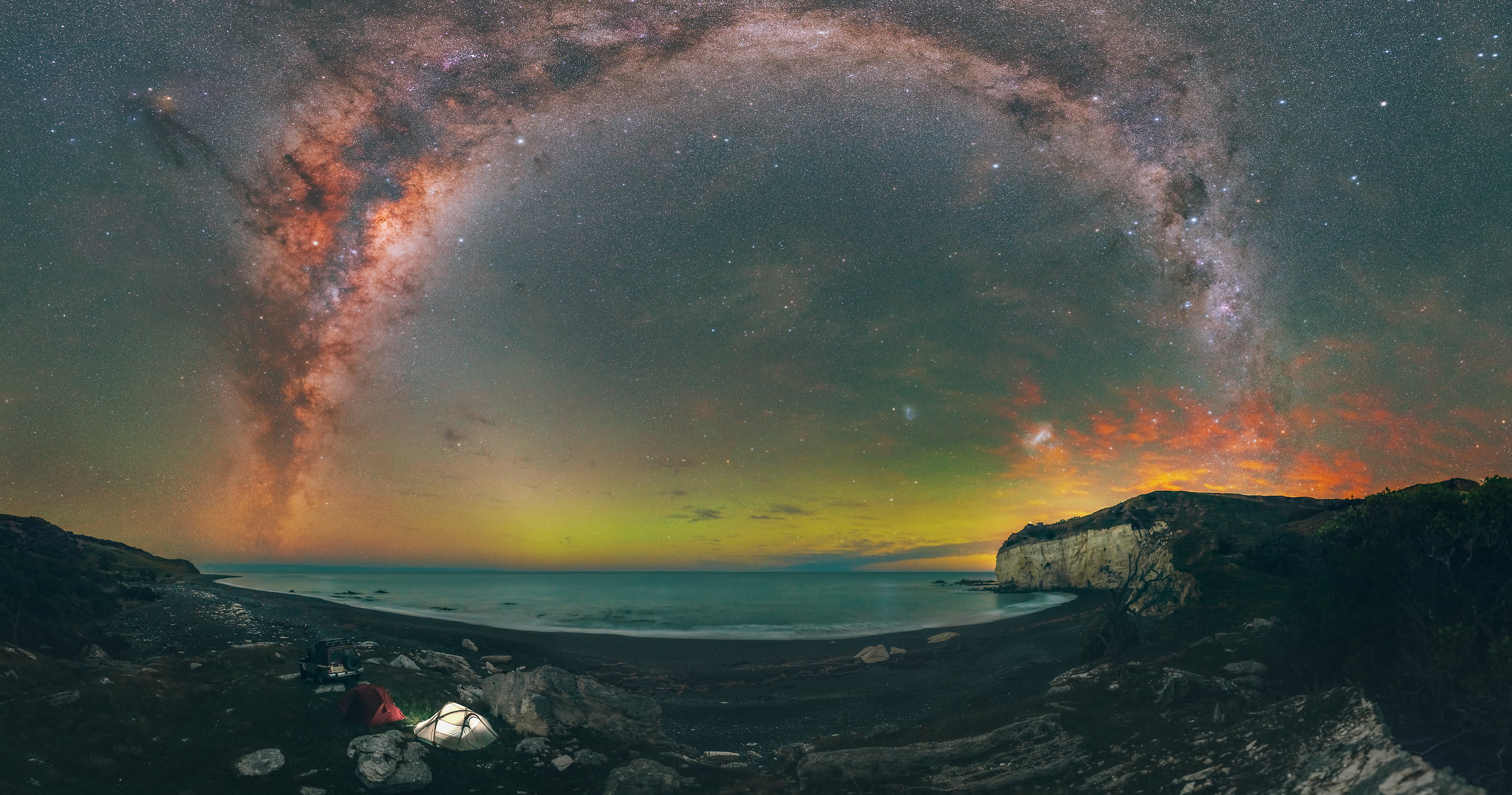 691 megapixels! A very high resolution, large-format VAST photo print of the night sky, milky way, and stars over an ocean beach with tents and camping equipment; fine art astrophotography landscape photo created by Paul Wilson in New Zealand.