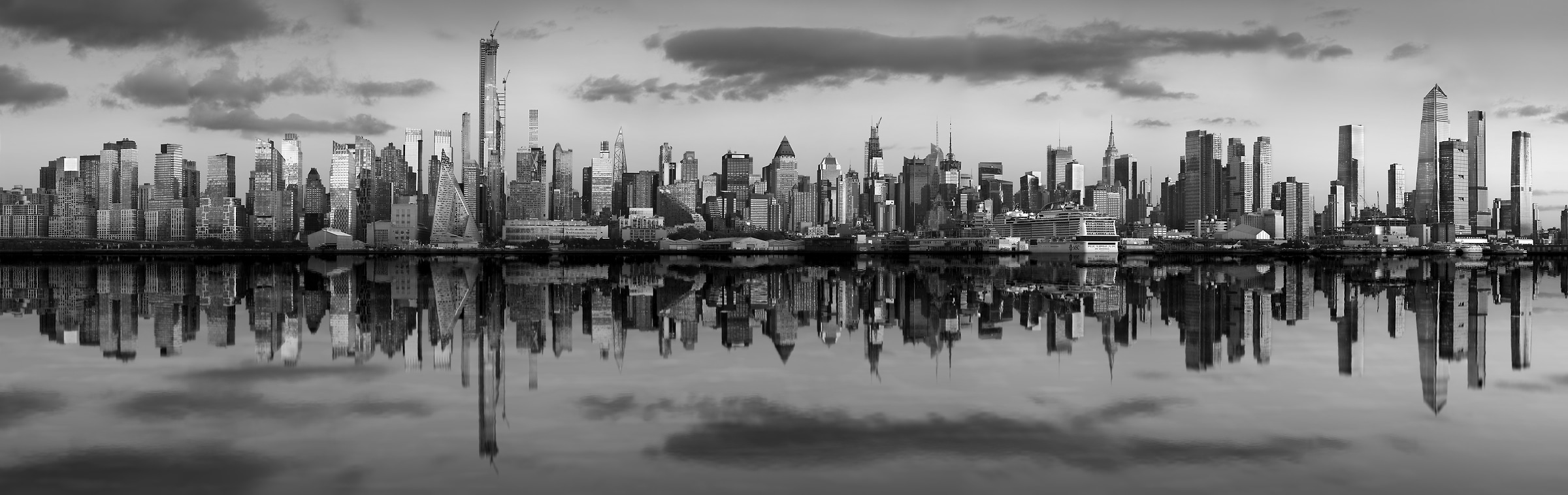 922 megapixels! A very high resolution, black & white VAST photo print of the New York skyline at sunset reflecting in the Hudson River; panorama photograph created by Phil Crawshay in New York, Manhattan.