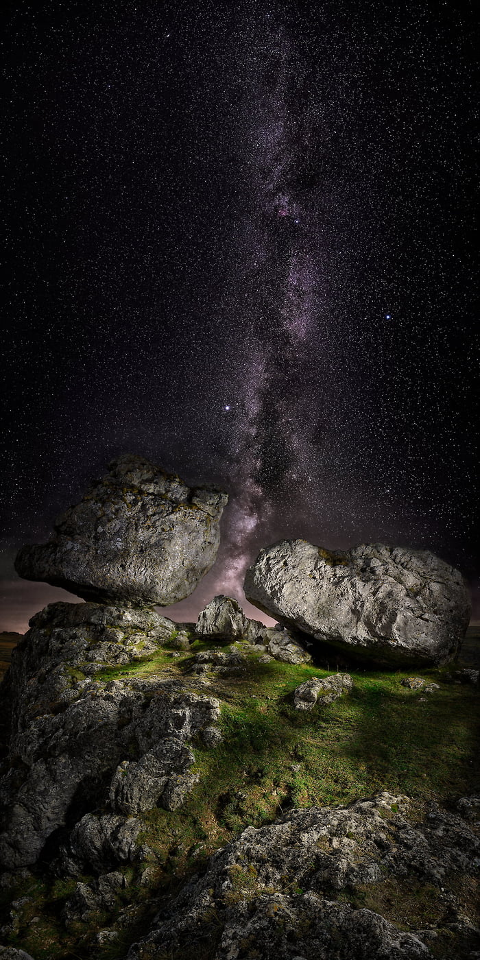 203 megapixels! A very high resolution, large-format VAST photo print of the Milky Way behind illuminated rocks on a grassy hill; astrophotograph created by David Meaux in Chaos de Nîmes-le-Vieux, Vebron, Lozère, France.