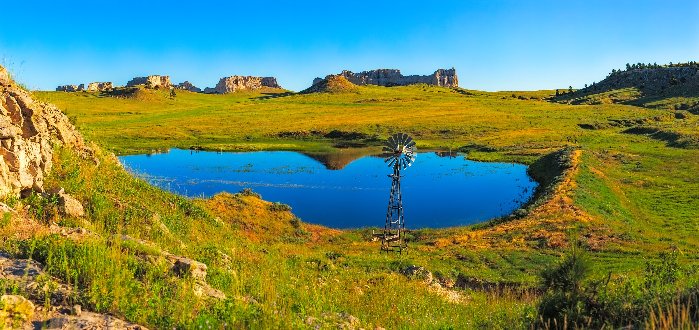 619 megapixels! A very high resolution, large-format VAST photo print of a Wyoming landscape with fields, a pond, and a windmill; photograph created by John Freeman in Keeline, Wyoming.