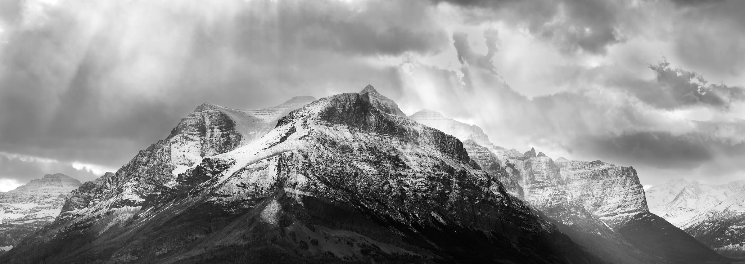 276 megapixels! A very high resolution, large-format VAST photo print of a mountain range with sun rays streaming onto it; black & white landscape photograph created by David David in Glacier National Park, Montana.