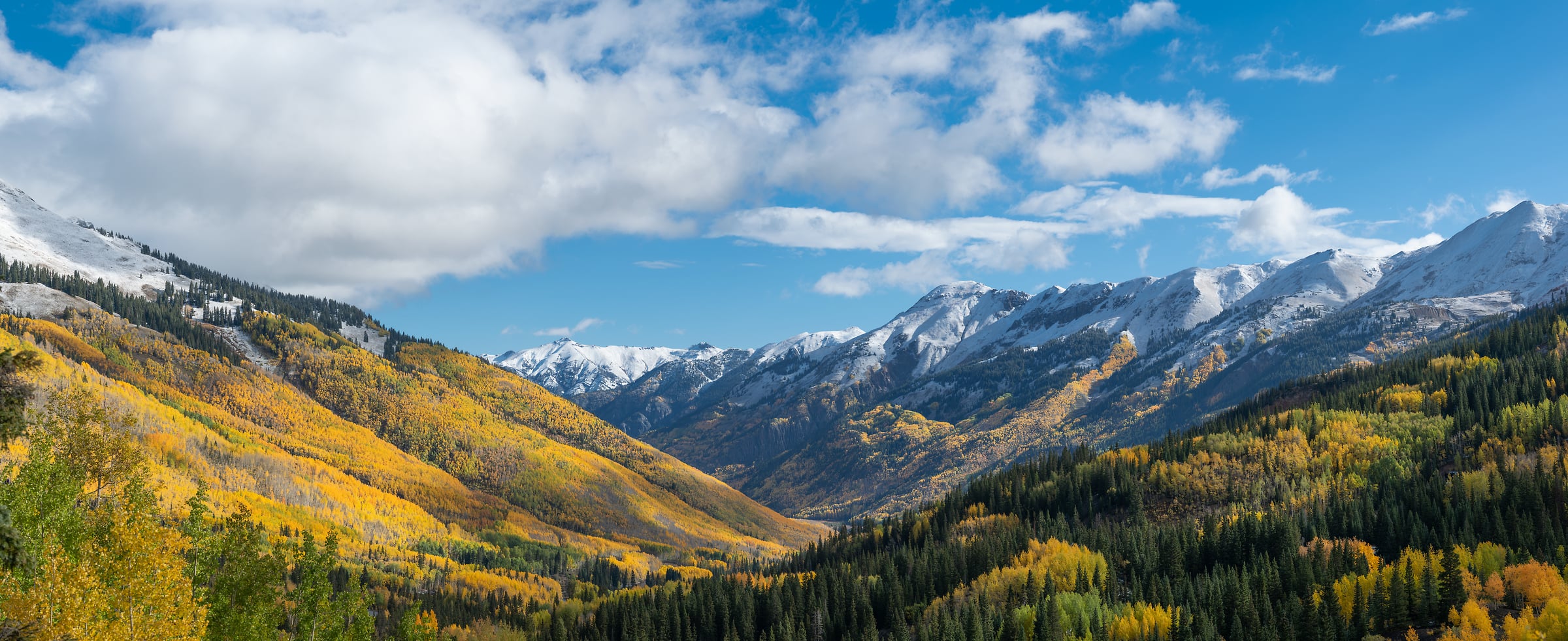 410 megapixels! A very high resolution, large-format VAST photo print of mountains with a valley during autumn with fall foliage and a blue sky with puffy clouds; landscape photograph created by Greg Probst in Red Mountain Pass, Colorado.