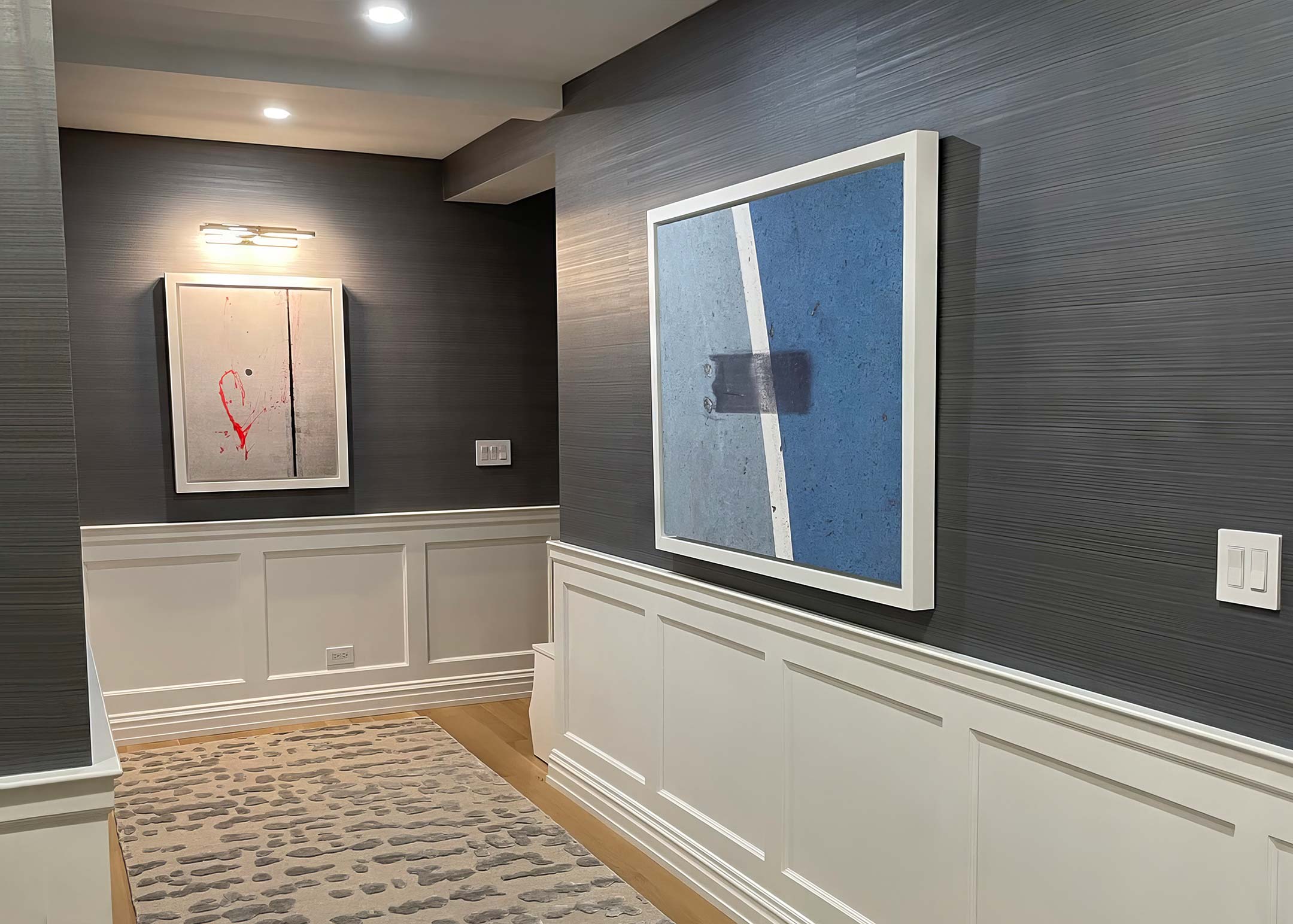 A picture of two framed, New York City fine art photographs hanging on the walls of a beautiful hallway.