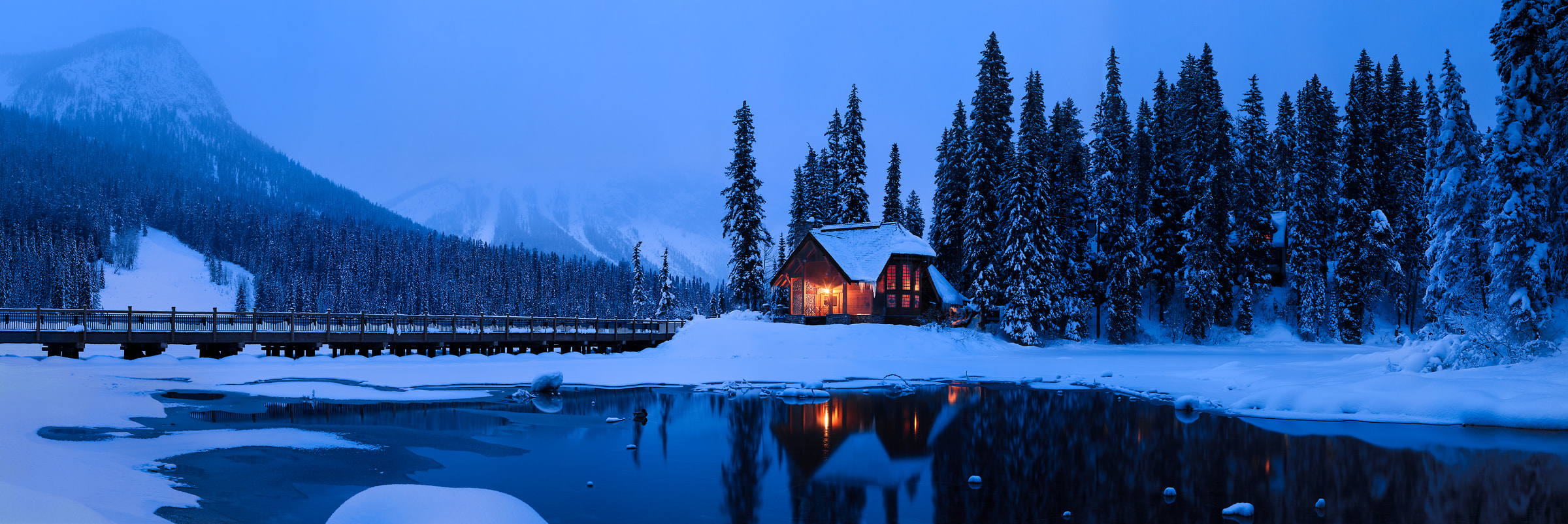 690 megapixels! A very high resolution, large-format VAST photo of a cozy winter scene with a snow covered forest, icy lake, a warm ski cabin in the woods, and snowy mountains; large-format photo print created at twilight by Scott Dimond in Yoho National Park, British Columbia, Canada