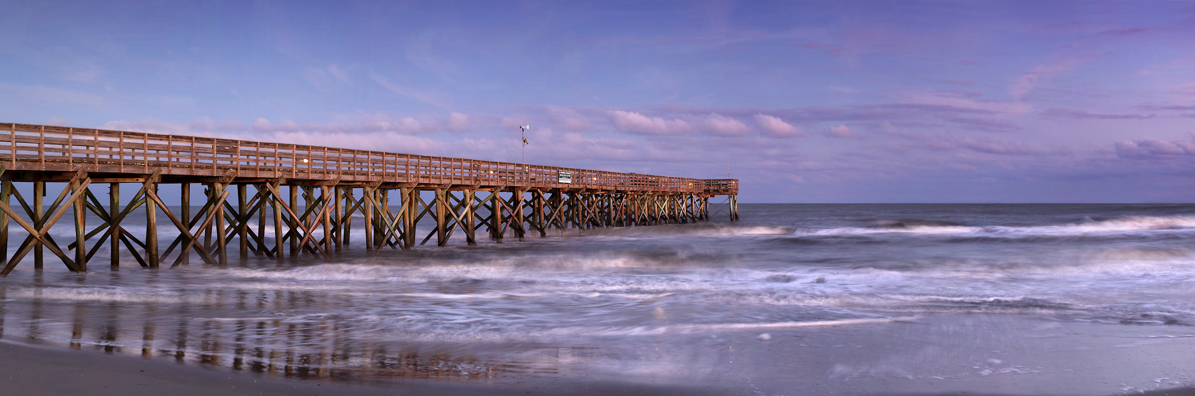 372 megapixels! A very high resolution, large-format VAST photo print of a beach with a pier going out into the ocean at sunset; photograph created by Phil Crawshay in Isle of Palms, South Carolina.
