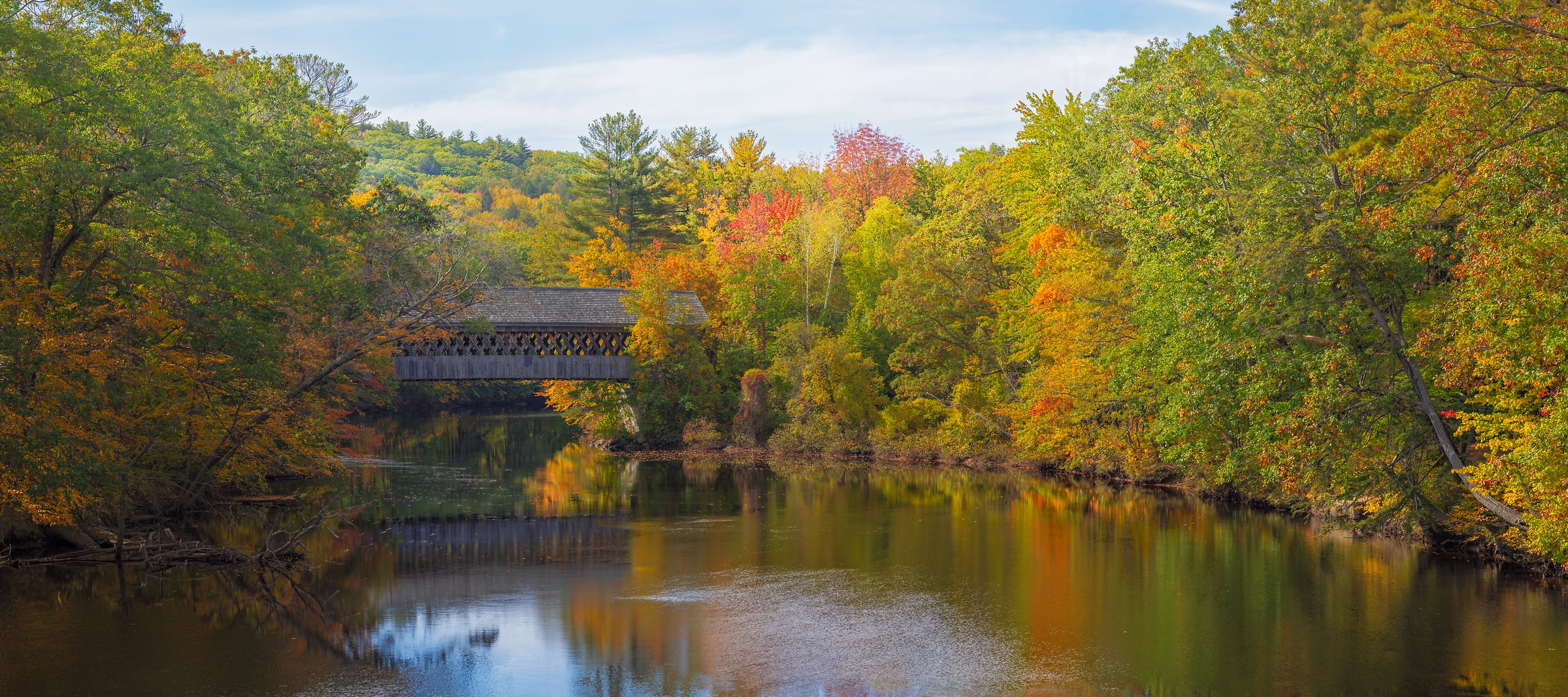 674 megapixels! A very high resolution, large-format canvas photo of a New England scene with a covered bridge of a river and autumn foliage; photograph created by John Freeman in Bridge Street, Henniker, New Hampshire
