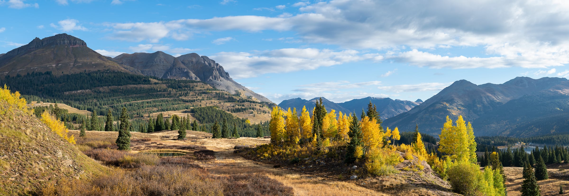 521 megapixels! A very high resolution, large-format VAST photo print of Molas Pass in Colorado in autumn with mountains, trees, fall foliage, and a beautiful blue sky with white puffy clouds; landscape photograph created by Greg Probst in Molas Pass, Colorado.