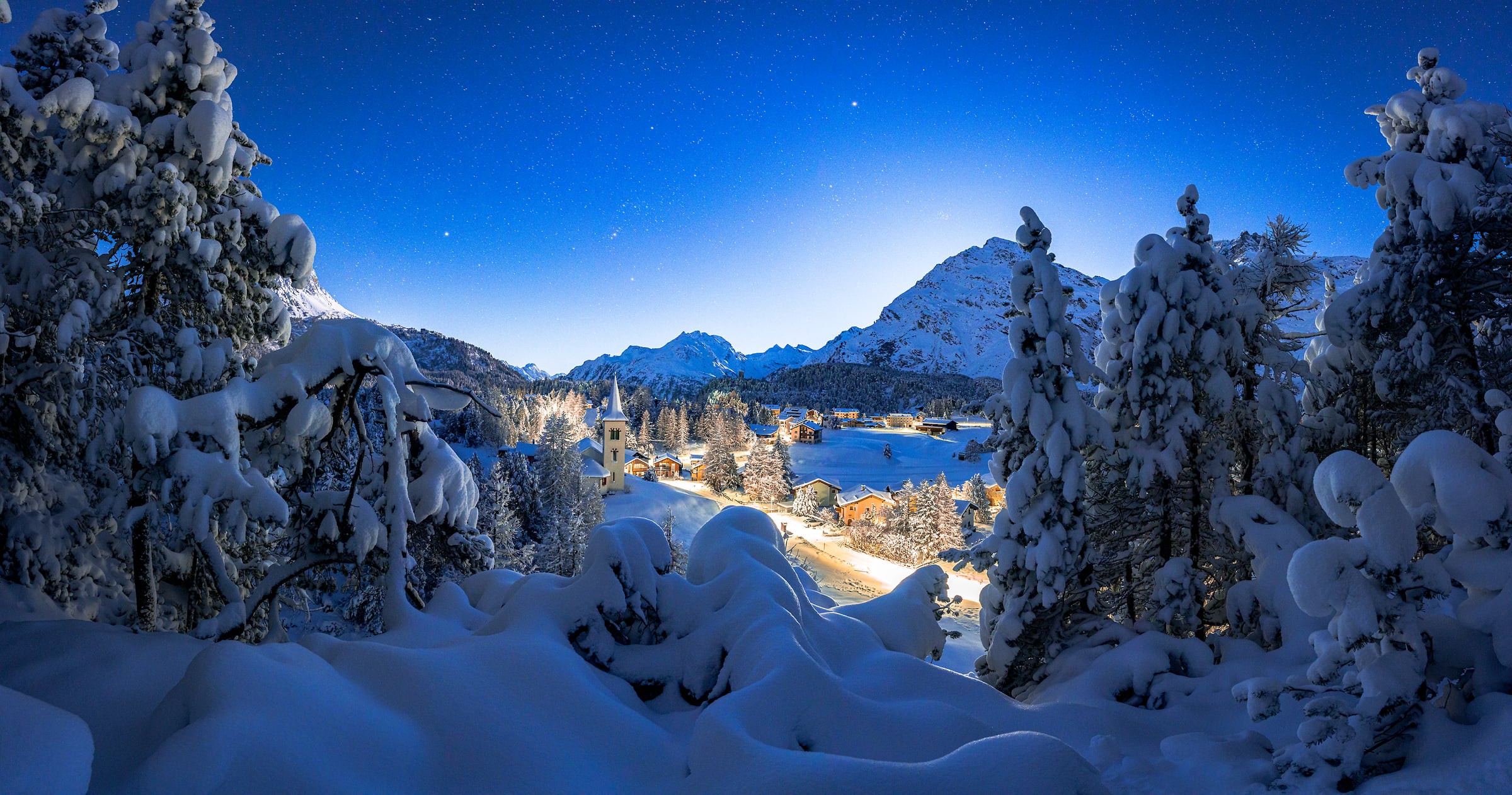 102 megapixels! A very high resolution, large-format VAST photo print of a white Christmas scene with snowy trees, a quaint town, mountains, the stars; art photograph created by Roberto Moiola in Maloja Pass, Switzerland.