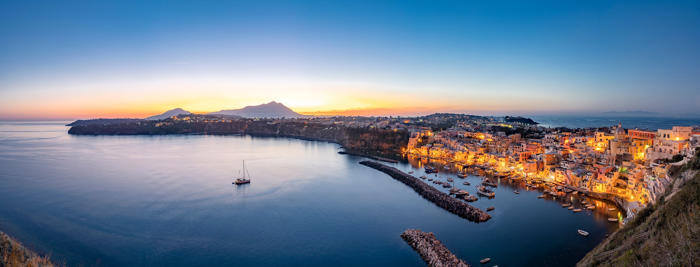 238 megapixels! A very high resolution, large-format VAST photo print of a peaceful harbor with boats and a city at dusk; landscape photograph created by Roberto Moiola in Procida, Naples, Italy.