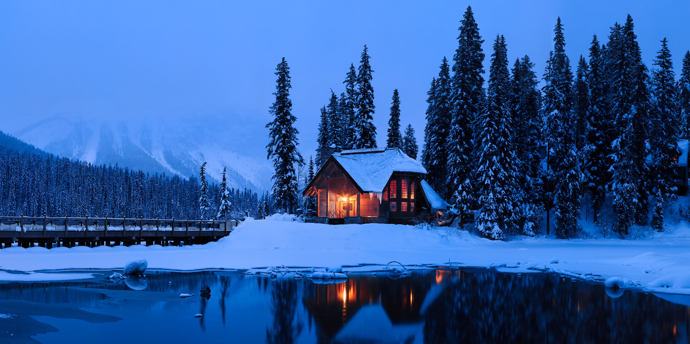 357 megapixels! A very high resolution, large-format VAST photo of a cozy nature scene with a snow covered forest, icy lake, a warm ski cabin in the woods, and snowy mountains; large-format photo print created at twilight by Scott Dimond in Yoho National Park, British Columbia, Canada.