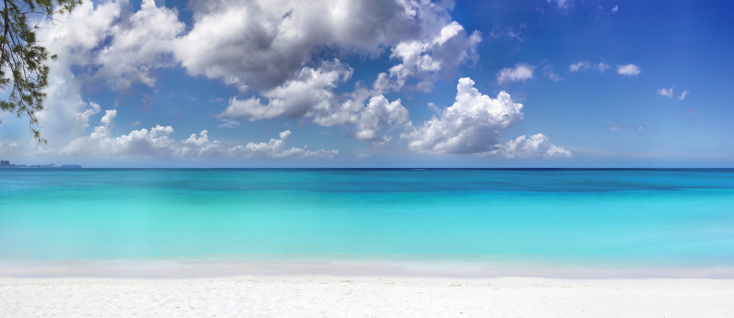 221 megapixels! A very high resolution, large-format VAST photo print of a calm blue ocean with a white sand beach in the foreground and puffy white clouds in the sky; photograph created by Phil Crawshay at Seven Mile Beach in West Bay, Cayman Islands.