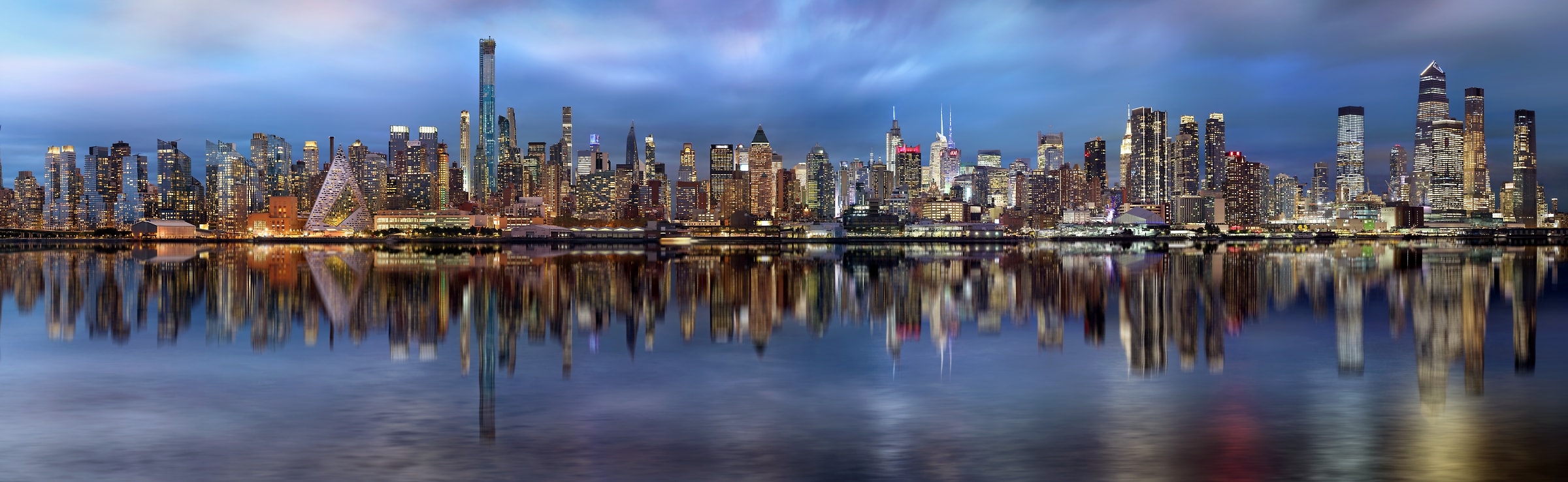 1,107 megapixels! A very high resolution, gigapixel panorama photo of the Manhattan skyline at dusk with the Hudson River in the foreground; cityscape photograph created by Phil Crawshay of New York City.