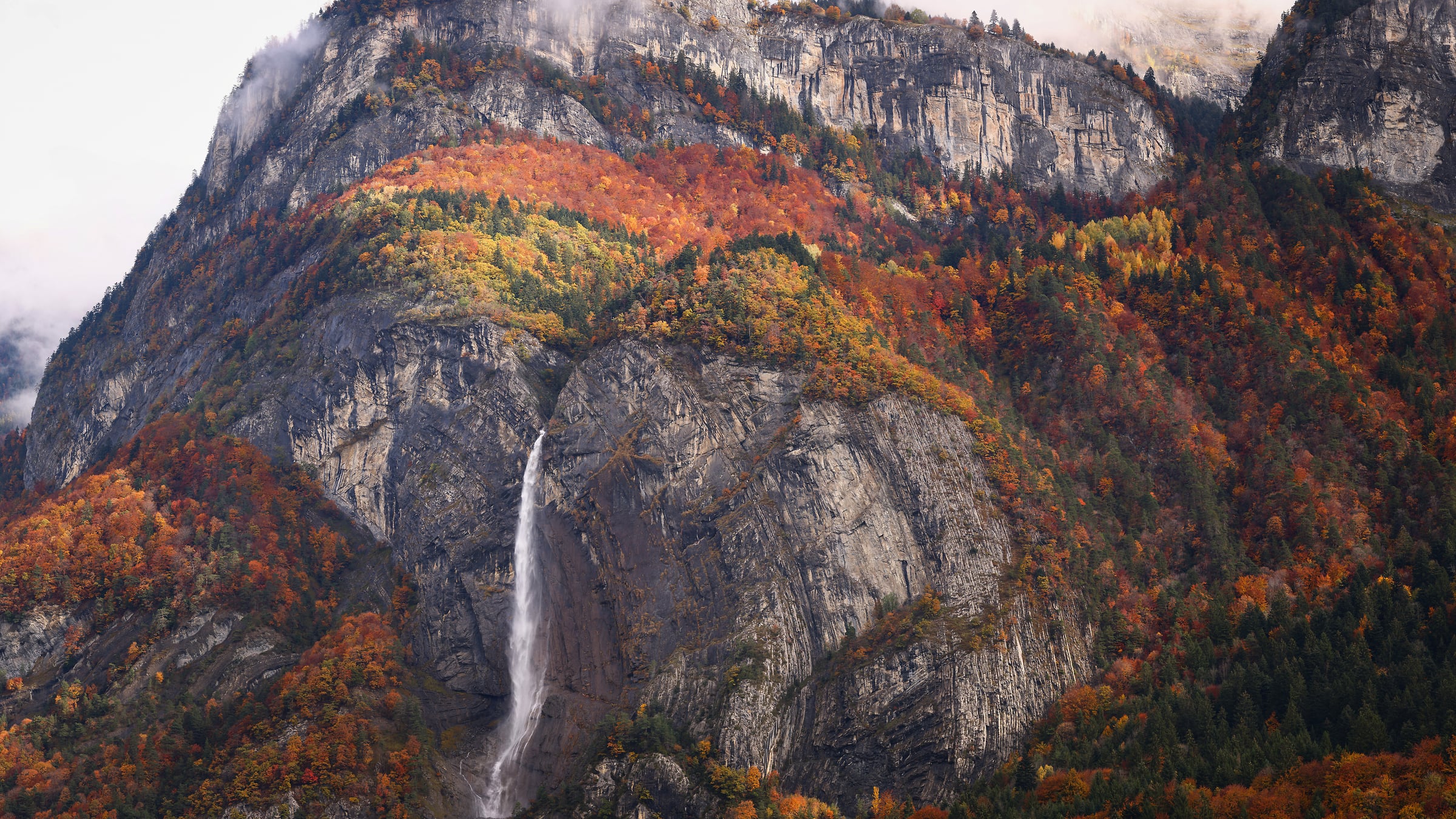 386 megapixels! A very high resolution, large-format VAST photo print of a waterfall on a rock wall of a mountain with trees and autumn foliage; landscape photograph created by Alexandre Deschaumes.