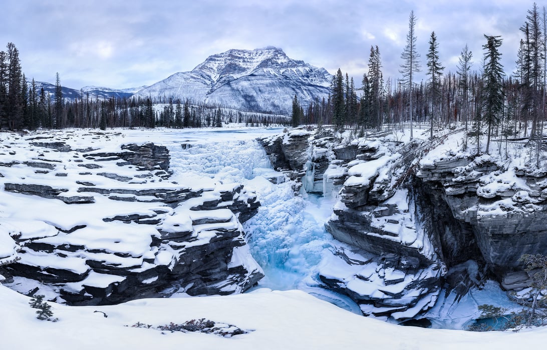 683 megapixels! A very high resolution, large-format VAST photo print of Jasper National Park in winter with Athabasca Falls frozen, snow covering the ground, and mountains in the background; wintertime landscape photograph created by Scott Dimond at Athabasca Falls in Jasper National Park, Alberta, Canada.